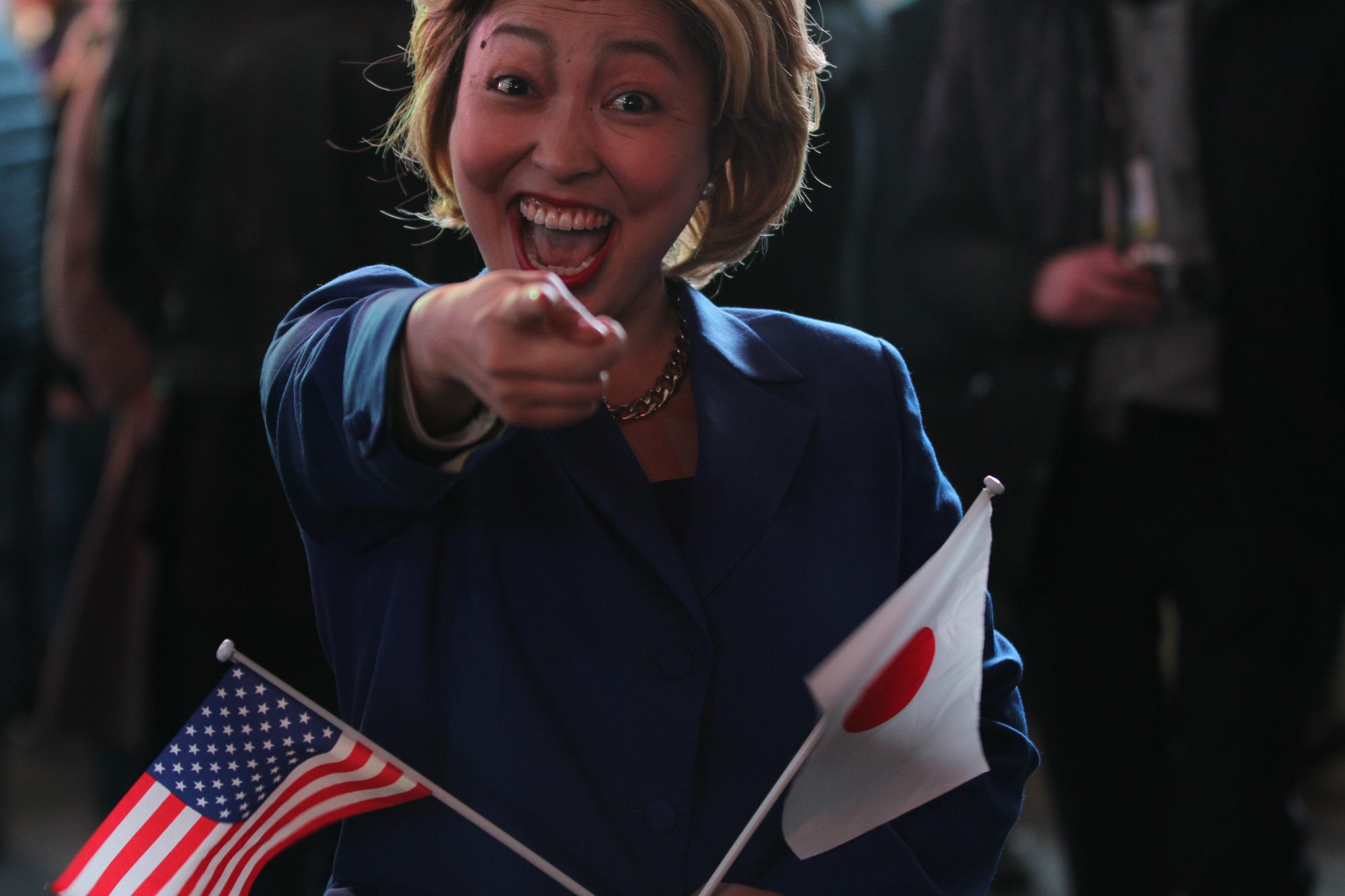 Earlier in the night, surrounded by hundreds of people in Times Square, a woman from Tokyo, Japan, dressed up as Democrat Hillary Clinton rallies enthusiasm among the crowd. (Rishika Dugyala/MNS)