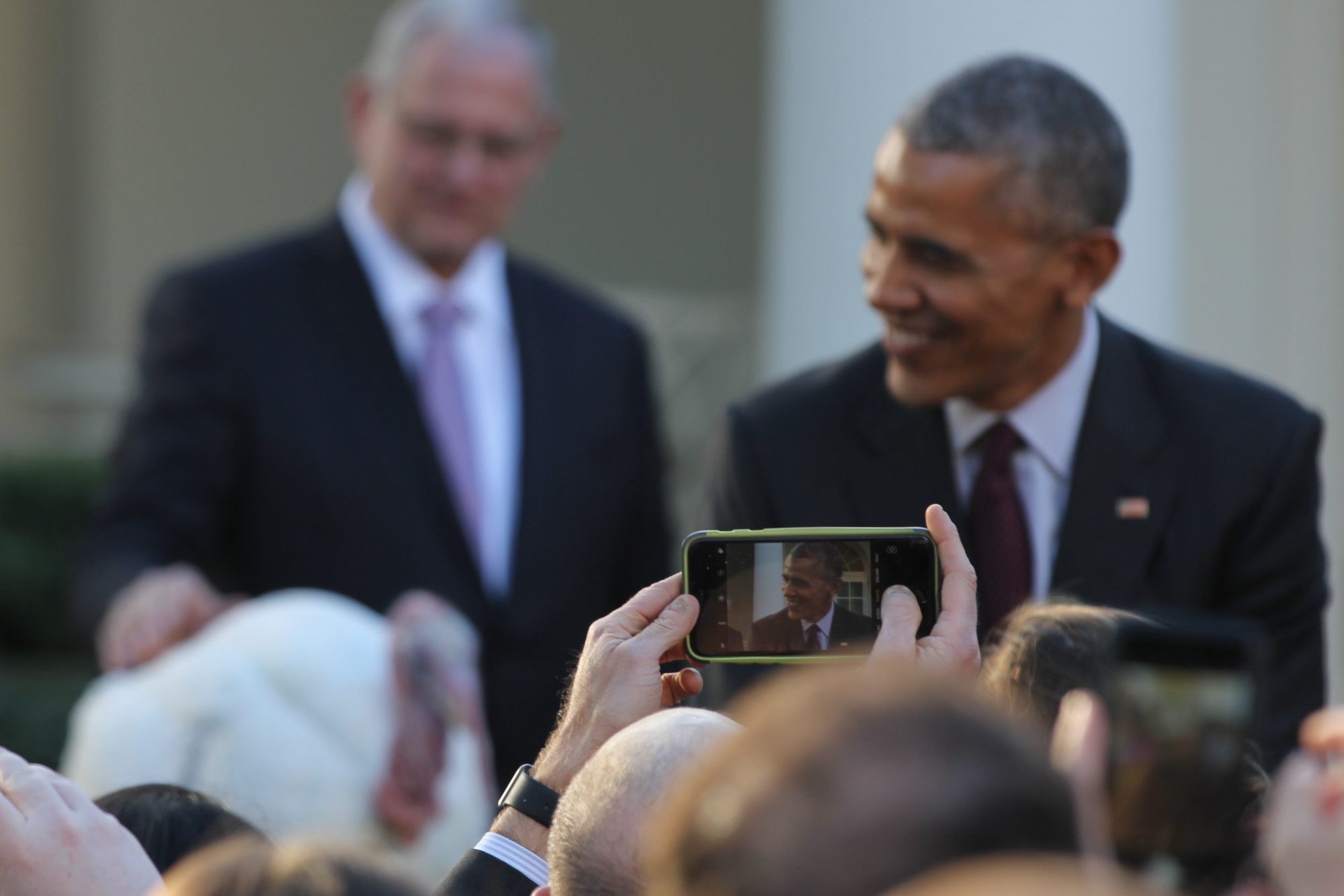 Obama poses with Tot as the crowd eagerly takes photos of them.