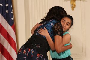 Obama hugs Joeslyn Hernandez, 12, from the Sphinx Overture Organization in Detroit, MI. The organization provides free after-school music education to students in the Flint and Detroit communities (Kelly Norris/MNS).