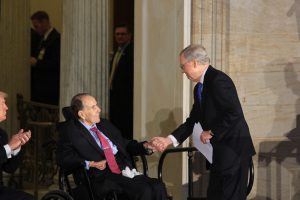 Senate Majority Leader Mitch McConnell greets his former Senate colleague, Sen. Bob Dole, before giving his remarks. "This soldier, statesman and American hero has never stopped fighting for those that have less power and less strength than he does," McConnell said. (Renzo Downey/MNS)