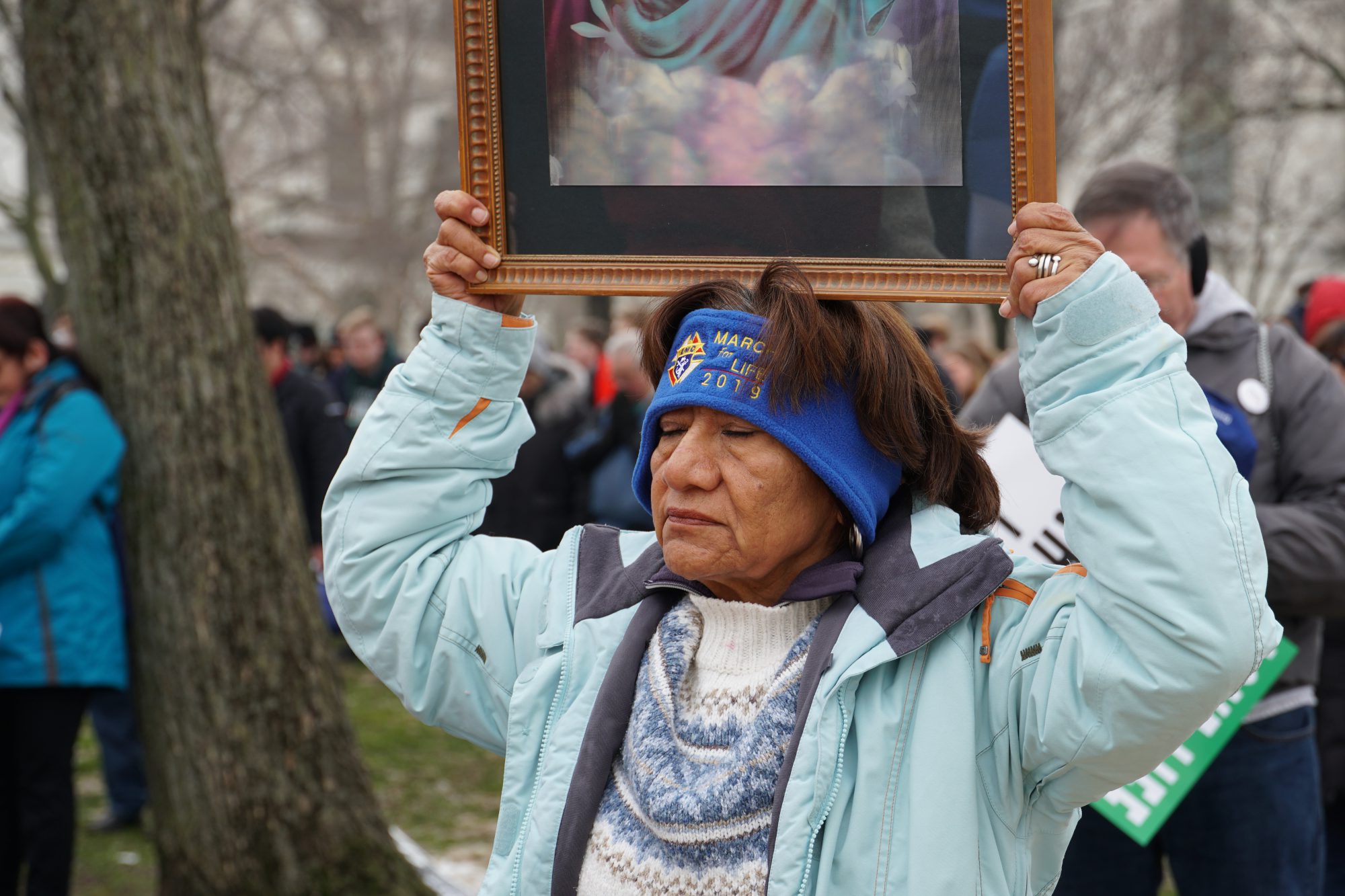A woman holds up an image of Jesus during the prayer. (Ester Wells/MNS)