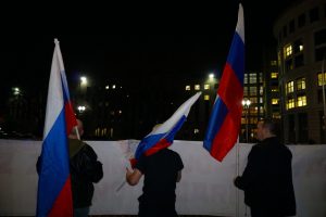 Protestors waved Russian flags as they waited along the sidewalk. (Ester Wells/MNS)