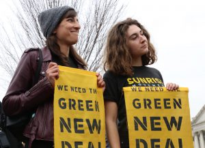 Members of the Sunrise movement held up signs that read, “We need the Green New Deal,” as they watched the press conference Thursday. (Dan Rosenzweig-Ziff/MNS)