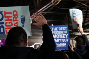 Supporters held up signs that read "Warren 2020" and "The Best President Money Can't Buy." (Ester Wells/MNS)