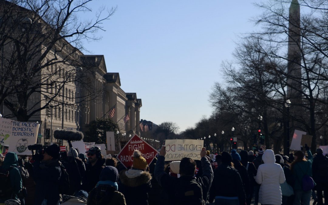 In Photos: Protesters walk out of work over Trump’s first year in office