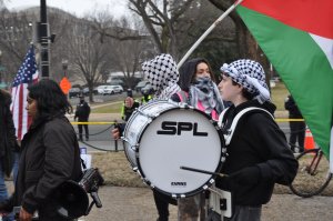 A protester held up a cardboard doll of Trump and later several protesters poured red liquid from plastic water bottles over the model. (Cate Bouvet/MNS)