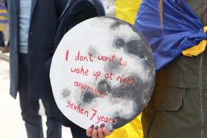 One protester held a sign bearing the words a 7-year-old Ukrainian child shared with a psychologist. (Chloe Park/MNS)