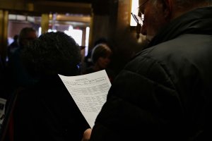 Participants consult a list identifying lawmakers who support the joint resolution to navigate between multiple congressional offices. (André Hiroki/MNS)