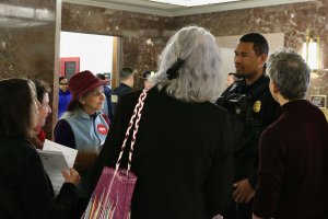 Community advocates speak to a United States Capitol Police officer during the Free DC action. (André Hiroki/MNS)