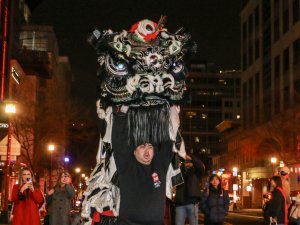 Members of the Hung Ci Lion Dance Troupe led onlookers through the streets of Chinatown Monday evening. (Melody Xu/Medill News Service)