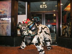 The lion dancers stopped in front of Chinatown storefronts in a symbolic offering of blessings. (Melody Xu/Medill News Service)