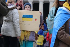 A young girl held a sign that said, “Glory to the heavens! Glory to the heroes!” in Ukrainian. (Sarah Han/MNS)