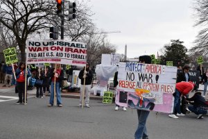 Protesters held signs calling for no war on Iran and for the release of the Epstein files, in the name of protecting America. (Brooke Sharp/MNS)