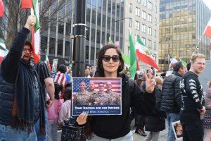 A demonstrator held a sign with four U.S. service members killed by an Iranian airstrike in Kuwait on March 1. (Brooke Sharp/MNS)