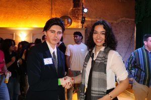 A participant in heavy contour shook hands with fellow contestant Medill News Service’s Isabel Papp. (Chloe Park/MNS)